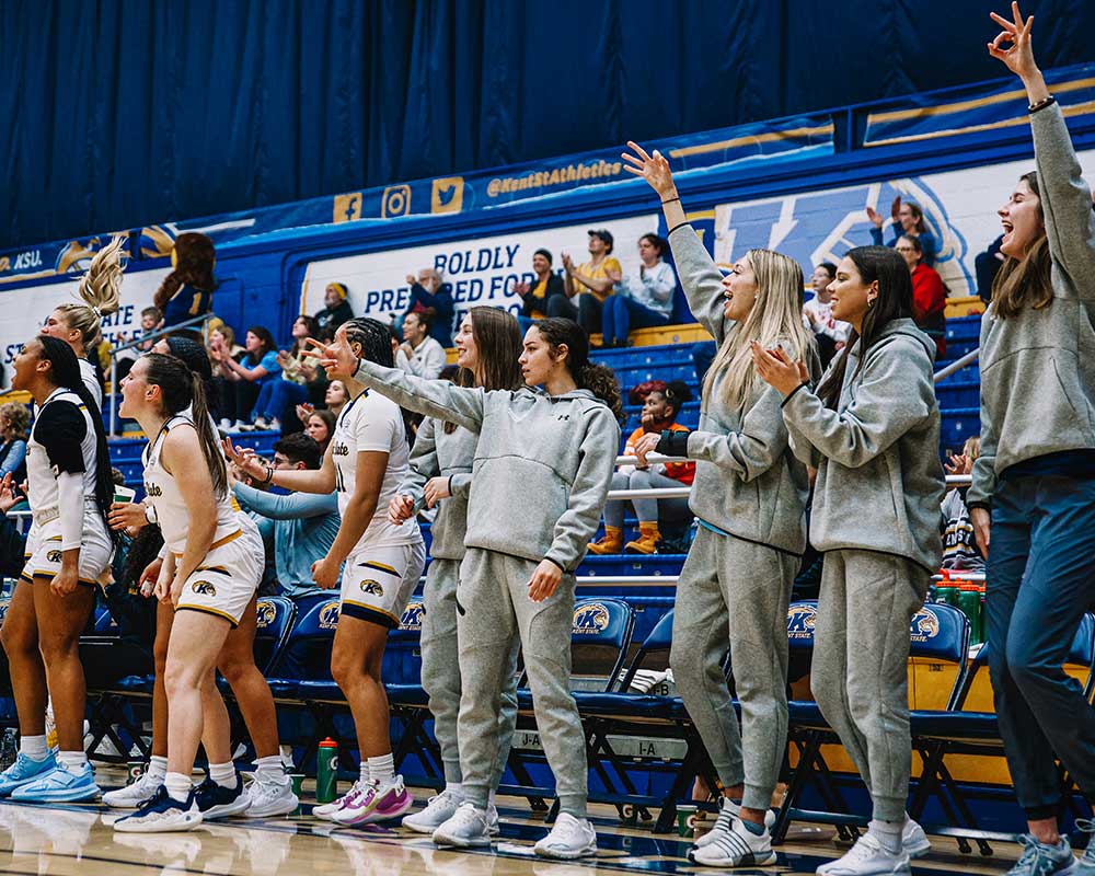 Team members celebrating at women’s basketball game